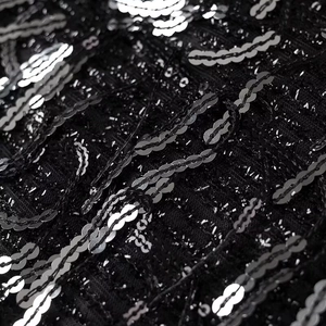 Macro detail of black fabric with wavy silver sequins for elegant party mini dresses