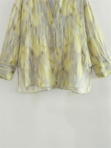Detail der lockeren Baumwoll-Leinen-Bluse mit gelb-grauem abstrakten Aquarellmuster und Schlitzen