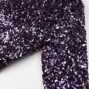 Vue détaillée de paillettes violettes et noires sur une mini robe moulante