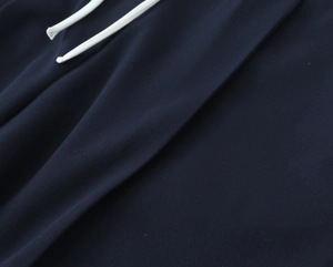 Detail der marineblauen Strickstoffstruktur mit weißem Kordelzug an Freizeithosen