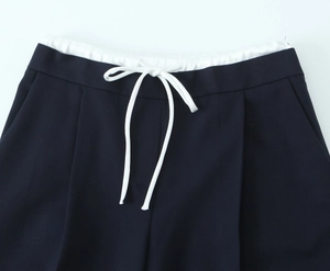 Detail der dunkelblauen Hose mit weißem Gummizug, Kordelzug und Seitentaschen