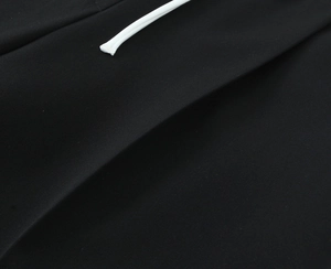 Detail der schwarzen Strickstoffstruktur mit dickem weißem Kordelzug an der Hose