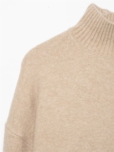 Détail du col montant côtelé et de l'épaule tombante sur un pull en maille douce