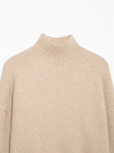 Gros plan détaillé sur la maille beige à col montant et la texture du tissu premium