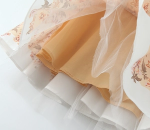 Dettaglio del tessuto a fiori con sovrapposizione in rete bianca e fodera arancio