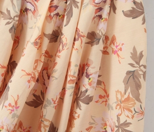 Dettaglio del tessuto in chiffon floreale con rose vintage e trama plissettata