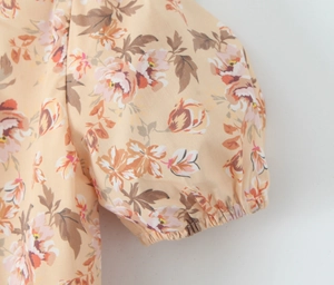 Dettaglio delle maniche a sbuffo floreali con polsini elastici su abito stile vintage