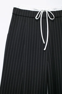 Detail der schwarzen Nadelstreifenhose mit weißem Kordelzug am elastischen Bund