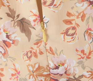 Dettaglio della cerniera invisibile su abito vintage a fiori con cursore in metallo