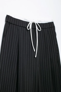 Detail einer schwarz-weiß gestreiften Hose mit elastischem Bund und Kordelzug