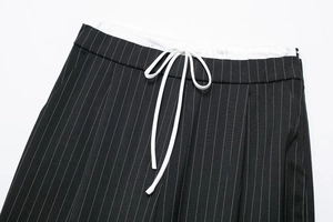 Detail des elastischen Bundes mit weißem Kordelzug an der schwarzen Nadelstreifenhose