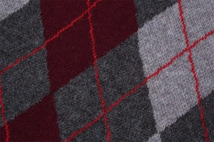Close-up of diamond argyle knit texture in burgundy and grey with red stitching