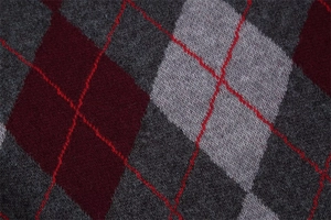 Macro detail of argyle knit fabric with red diamond stitching and soft wool texture