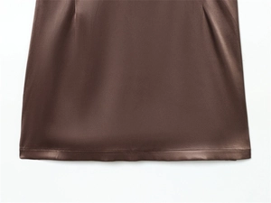 Gros plan sur l'ourlet en satin marron foncé avec des coutures soignées d'une robe dos nu