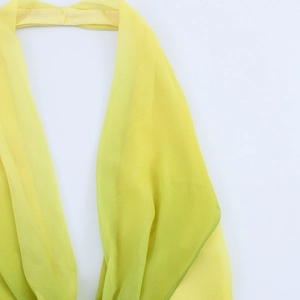 Detail of light yellow floral halter neck dress fabric with delicate sheer texture