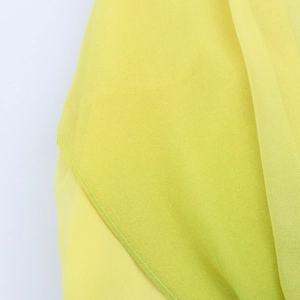 Macro shot of fine yellow floral fabric showing precise stitching and hem detail