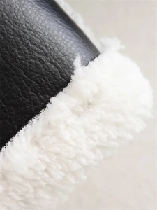 Close-up of black pebble leather and thick white sherpa lining on winter jacket