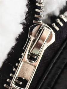 Detail of silver metal zipper on winter jacket with thick white fleece lining texture