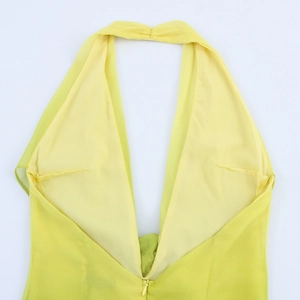 Detail of yellow halter neckline with deep V-neck and invisible zipper on floral fabric