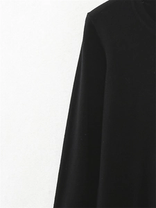 Detail of shoulder seam and smooth knit fabric on black long sleeve crewneck top