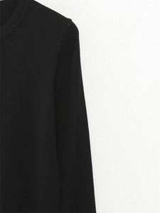 Close-up detail of the classic round neckline and shoulder of this minimalist black knit top