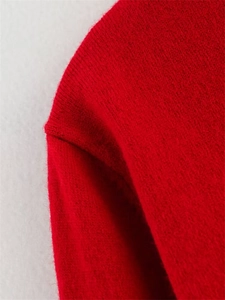 Gros plan détaillé montrant la texture douce du tricot et la couture de l'ensemble rouge
