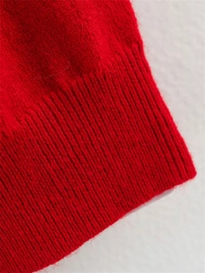 Gros plan sur la maille côtelée rouge montrant la couture élastique et le tissu en laine doux