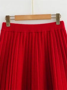 Détail de la jupe plissée en maille rouge avec taille élastique et texture verticale