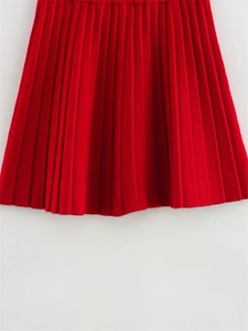 Détail d'une jupe plissée rouge en maille avec une texture accordéon verticale fine