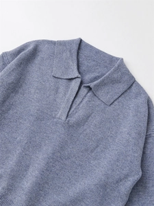 Détail du col polo en maille et décolleté en V profond en bleu poussiéreux