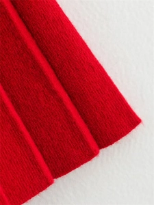 Gros plan sur la maille rouge vif montrant la texture douce et les finitions soignées