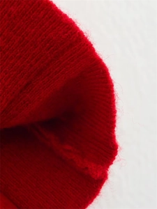 Détail macro de la maille côtelée rouge montrant le tissu doux en laine mélangée