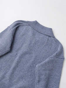 Détail d'un pull polo en maille bleu clair montrant la texture côtelée et le col