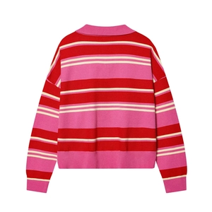 Macro detail of red and pink striped knit sweater showing texture and ribbed cuffs