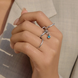 Detailed close-up of a silver titanium steel stacked ring featuring a light blue zircon charm