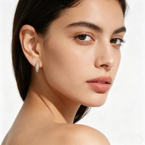 Close-up of S925 silver croissant hoop earring with wavy texture on female model