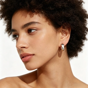Close-up of polished S925 silver hoop earrings worn by a model in a minimalist style