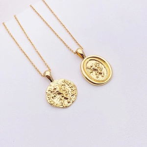 Close-up of 18k gold plated round coin pendants with vintage horse relief on cross chains