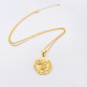 Detailed macro view of 18k gold plated lion coin pendant and textured o-chain necklace