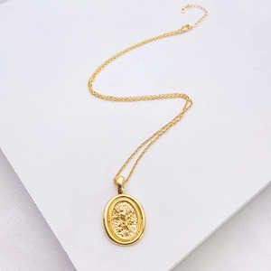 Minimalist 18k gold plated round lion crest medallion necklace for women on white background