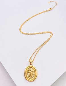 Detailed close-up of 18k gold plated lion relief coin pendant on a delicate cable chain