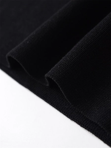 Detailed macro view of the soft black knit fabric texture and ribbed hem on the short sleeve top