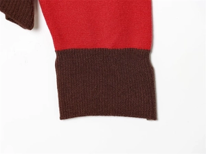 Detailed macro view of the striped knit sweater featuring red and brown ribbed cuffs