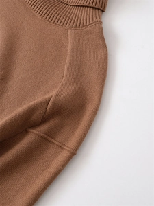 Detail view of the fine ribbing on the dark brown turtleneck knit sweater collar