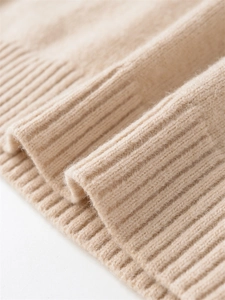 Macro shot of ribbed cuff detail on a cozy beige winter knit sweater for women