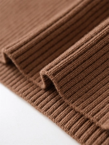 Macro shot of deep brown rib-knit fabric texture showing soft wool fiber details