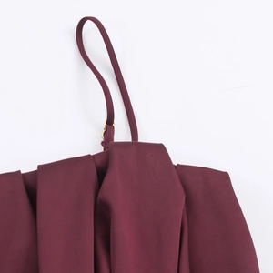Détail du haut bordeaux avec bretelles réglables et boucles en métal doré brillant