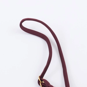 Détail d'une bretelle bordeaux avec anneau en métal doré sur un tissu en maille fine