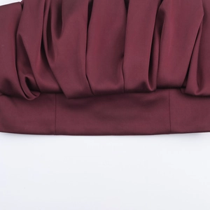 Détail du tissu satiné bordeaux avec plis raffinés et couture d'ourlet soignée