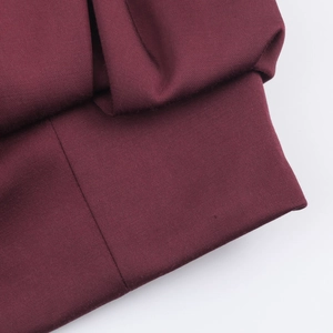 Macro du tissu sergé bordeaux montrant les coutures fines et les détails de texture